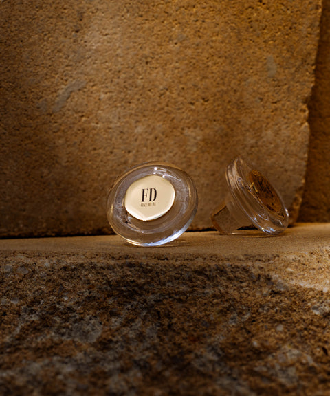 Zwei Glasverschlüsse von ONE RUM Flaschen, einer davon mit den Initialen „FD“. Diese Verschlüsse sind detailverliebt gestaltet und unterstreichen die Exklusivität der ONE RUM Kollektion.