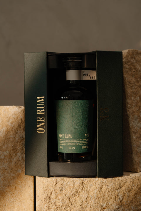 Flasche ONE RUM No. 3 in einer eleganten schwarzen Geschenkbox präsentiert. Der grüne Etikettentext und die Seriennummer 085/332 unterstreichen die Exklusivität und den Vintage-Charakter dieses 22 Jahre alten Single Cask Rums.